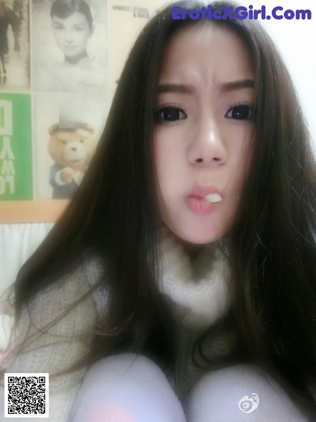 A woman with long black hair sticking out her tongue.