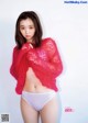 A woman in a pink sweater and white panties posing for a magazine.