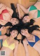 A group of young women laying on top of a wooden floor.