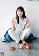 A woman sitting on the floor with a cup of tea.