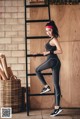 A woman standing on a ladder in a gym.