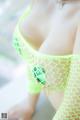 A woman in a yellow fishnet bikini with a green turtle on it.