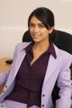 A woman in a purple suit sitting at a desk.