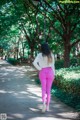 A woman walking down a path in a park.