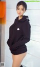 A woman in a black hoodie posing for a picture.