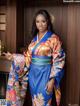 A woman in a blue and orange kimono posing for a picture.