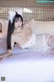 A woman in a white lingerie laying on a bed.