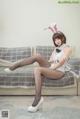 A woman in a bunny costume sitting on a couch.