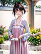 A woman in a pink kimono holding a cell phone.