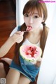 A young woman eating a slice of watermelon with a spoon.